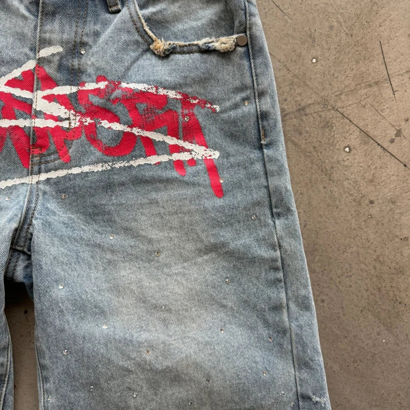 Denim shorts with red and white graphics on a brown surface