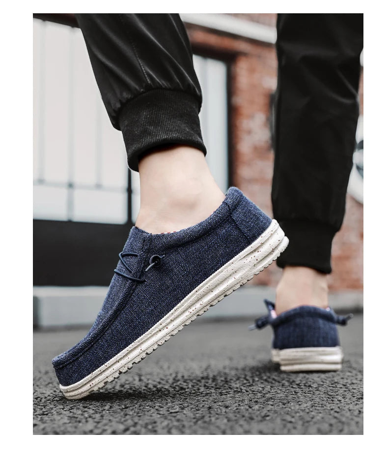 Blue casual shoes worn by a person on a pavement.