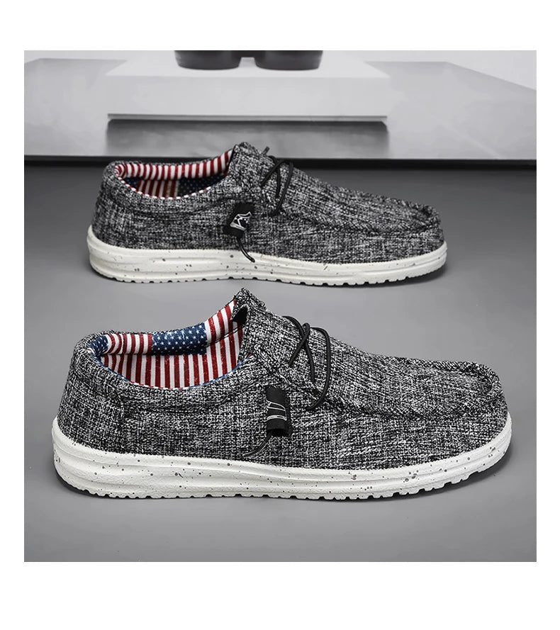 Pair of black & white casual shoes with American flag lining on a gray background