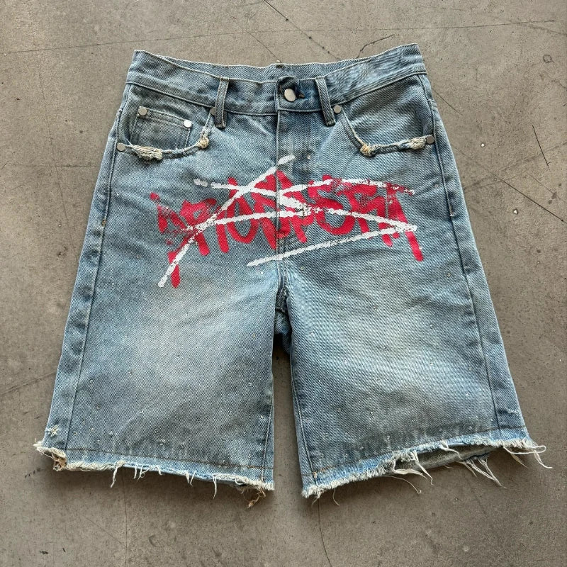 Denim shorts with red and white graphic on a concrete floor