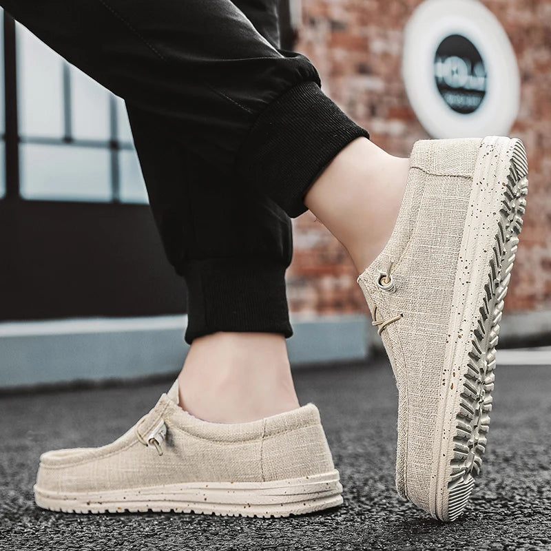 Beige slip-on shoes worn with black pants on a blurred background