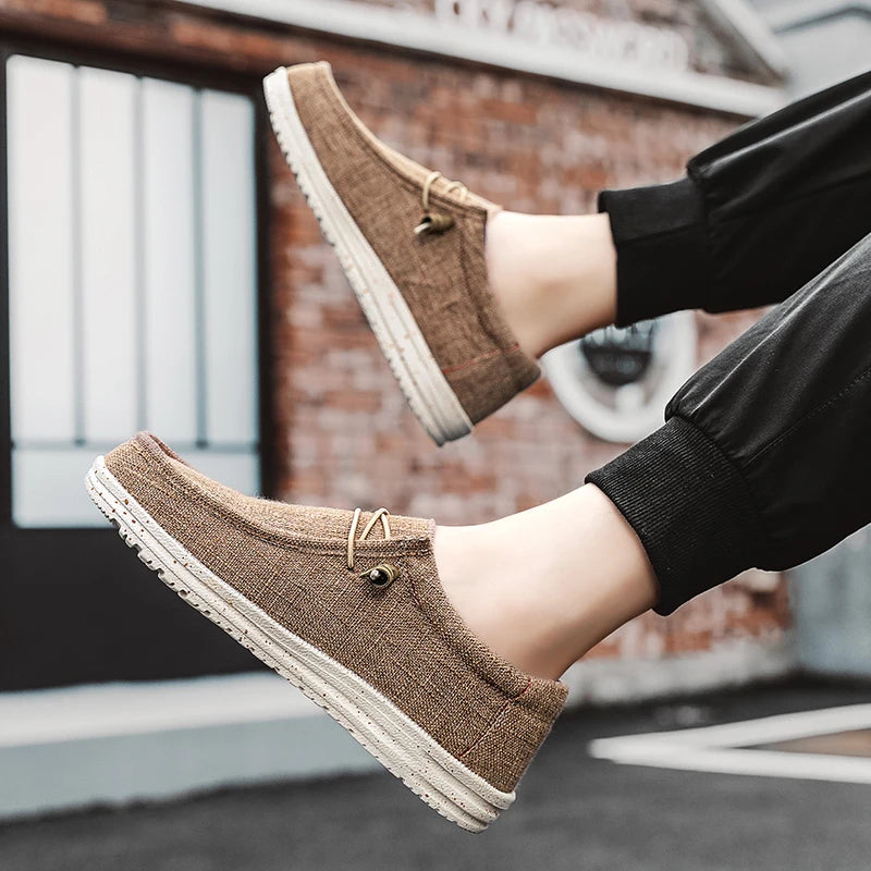 Brown loafers worn with black pants against a blurred urban background