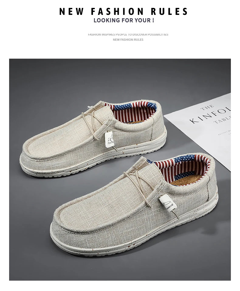 Pair of beige loafers with red, white, and blue lining on a gray background