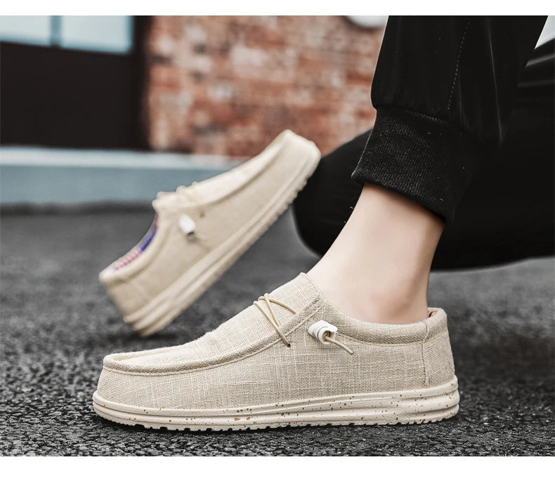 Beige loafers worn by a person on a dark surface with a blurred background