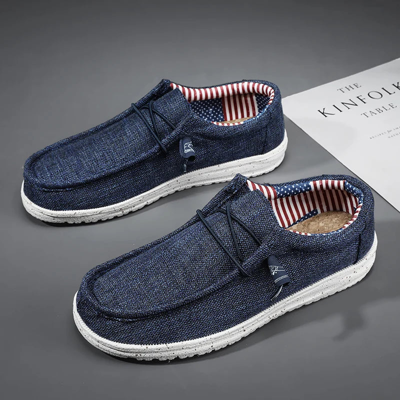 Pair of blue casual shoes with white soles on a gray surface.