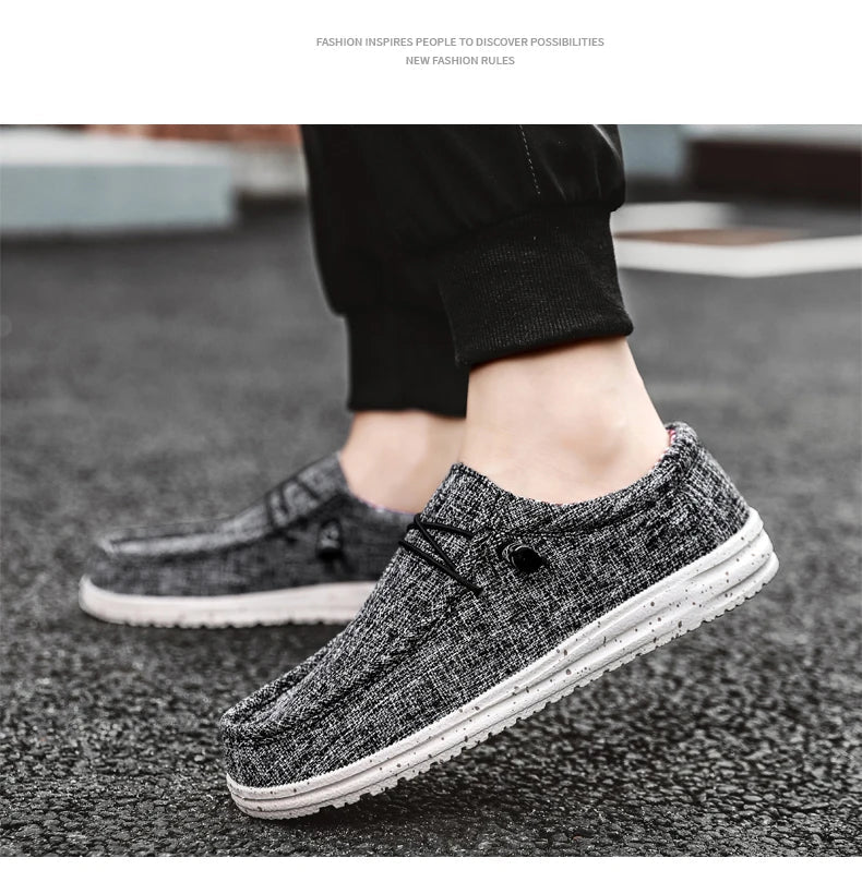 Black and white casual shoes worn by a person on a textured surface.